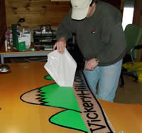 dave houle applies the vinyl to the smartbeetle vickeryhill.com sign